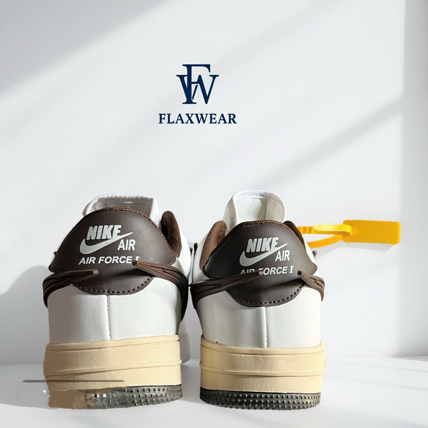 Back view of Nike Air Force 1 sneakers in white and brown with vintage sole and yellow tag by Flaxwears