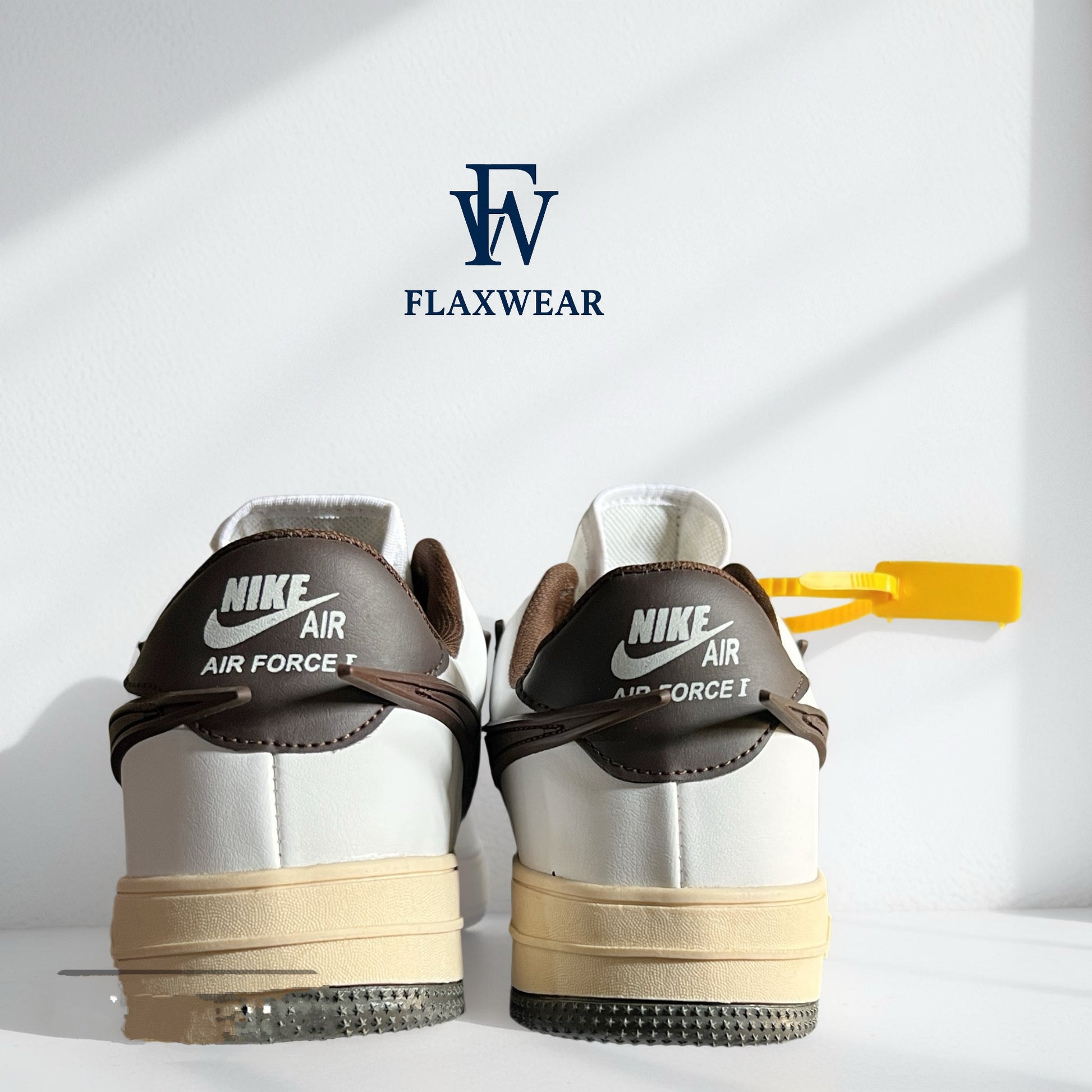 Back view of Nike Air Force 1 sneakers in white and brown with vintage sole and yellow tag by Flaxwears