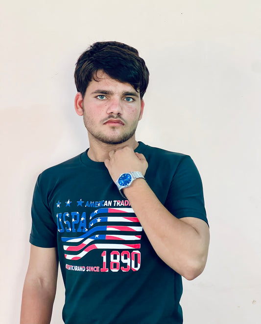 Young man wearing a navy blue US Polo Assn graphic t-shirt with American flag design and 1890 text